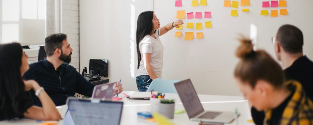 woman placing sticky notes on wall